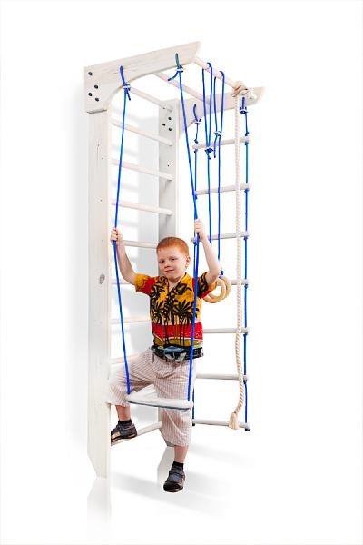 Biały kącik sportowy Bambino 220 cm z dzieckiem korzystającym z trapezu przy drewnianej drabince gimnastycznej.
