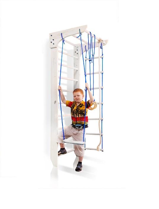 Kącik sportowy Bambino 220 cm biały z dzieckiem na trapezie oraz widoczną drabinką plecioną, pierścieniami i liną wspinaczkową.